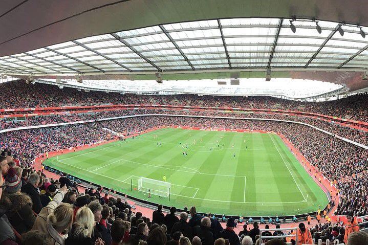 View of Emirates Stadium Football Pitch high up from the stalls on the inside, with a full crowd and players on the pitch.